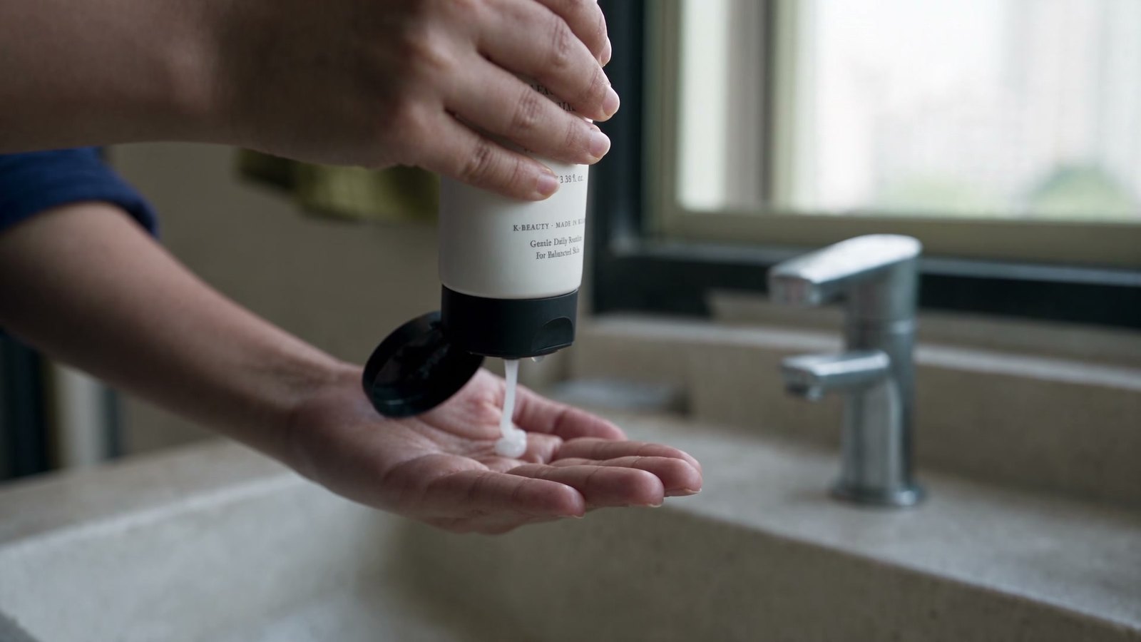 Squeezing cleanser into a palm at a sink