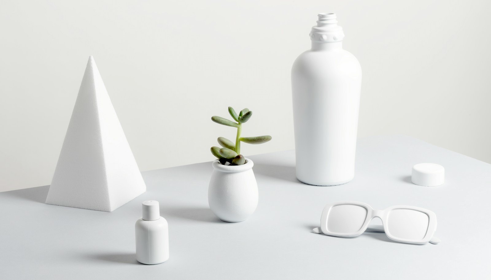 A few plain white bottles on a white table